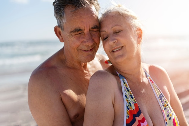 Anziani romantici di tiro medio in spiaggia