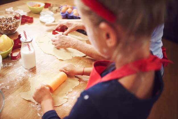 Anziano con i biscotti di cottura della ragazza a Natale