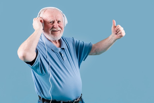 Anziano di vista laterale che mostra segno giusto per la musica