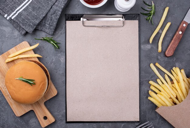 Appunti accanto a hamburger e patatine fritte