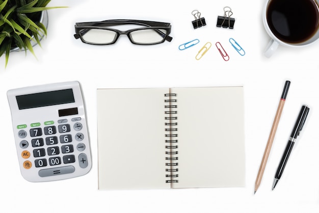 Apra spirale notebook e calcolatrice in bianco tavolo da scrivania