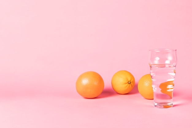 Arance e bicchiere d'acqua con lo spazio della copia