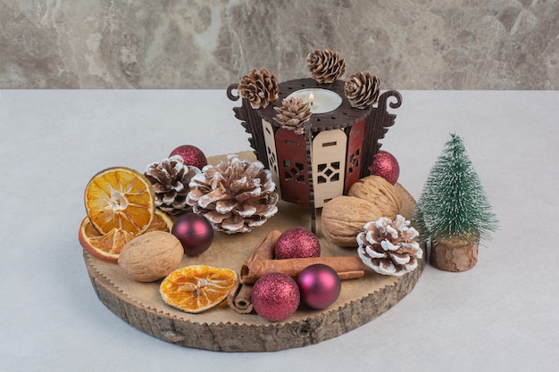 Arancia secca con pigne nelle quali e palle di Natale sul piatto di legno. Foto di alta qualità