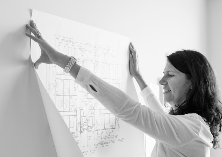 Foto gratuito architetto bianco che mostra il piano di costruzione sul muro bianco