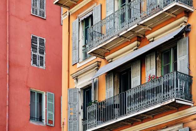 Architettura colorata delle finestre e dei balconi di un edificio rosso a Nizza, Francia