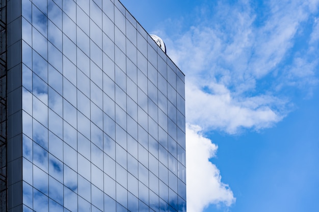 Architettura moderna della costruzione di vetro con cielo blu e nuvole