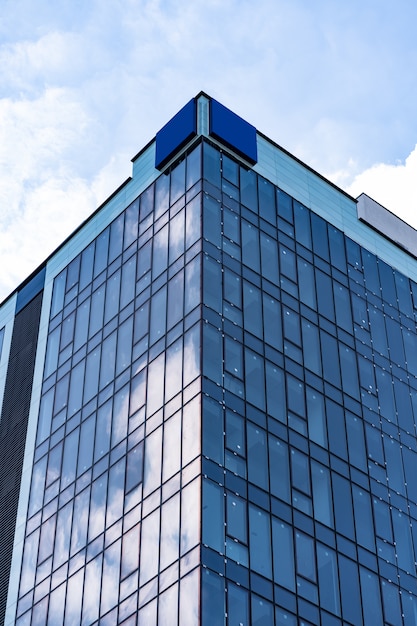 Architettura moderna della costruzione di vetro con cielo blu e nuvole