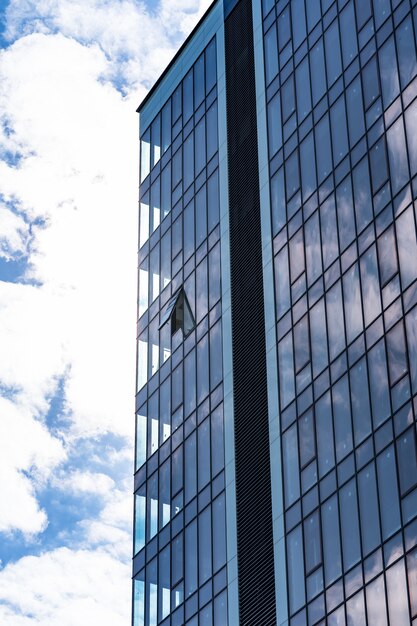 Architettura moderna della costruzione di vetro con cielo blu e nuvole