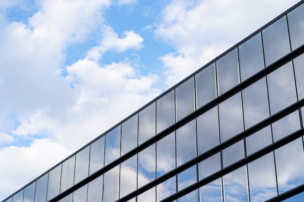 Architettura moderna della costruzione di vetro con cielo blu e nuvole