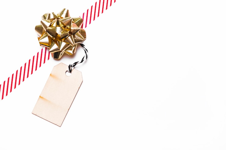 Foto gratuito arco regalo con nastro e tag sul tavolo
