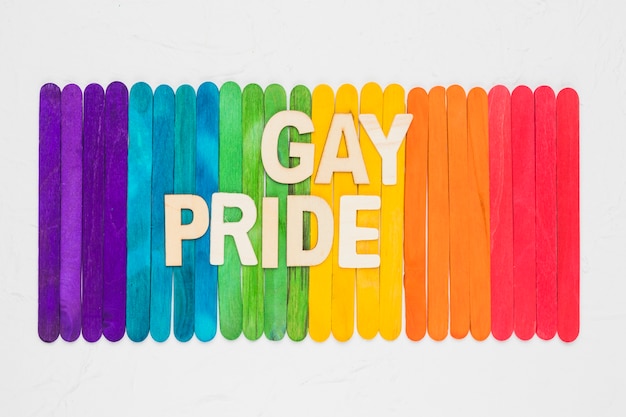 Arcobaleno luminoso di bastoncini di legno colorati e parole di orgoglio gay