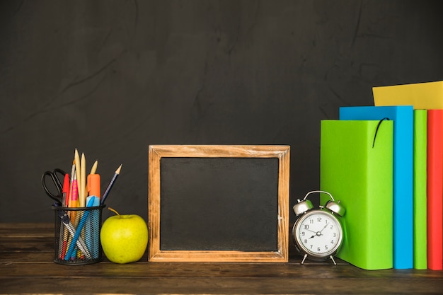 Area di lavoro con libri e cornice per lavagna