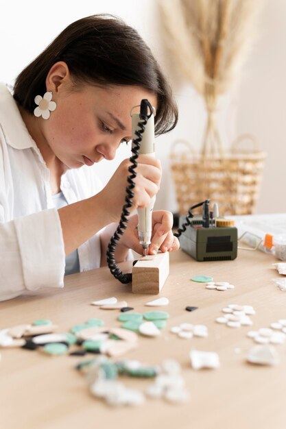 Artigiana che lavora nell'atelier con la pistola per colla