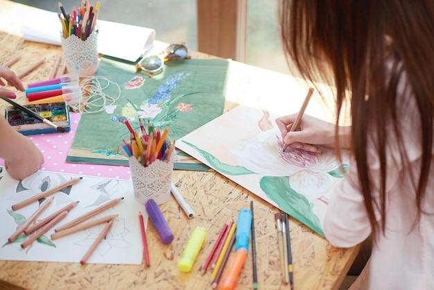 Artista che dipinge un bel fiore su un foglio di carta