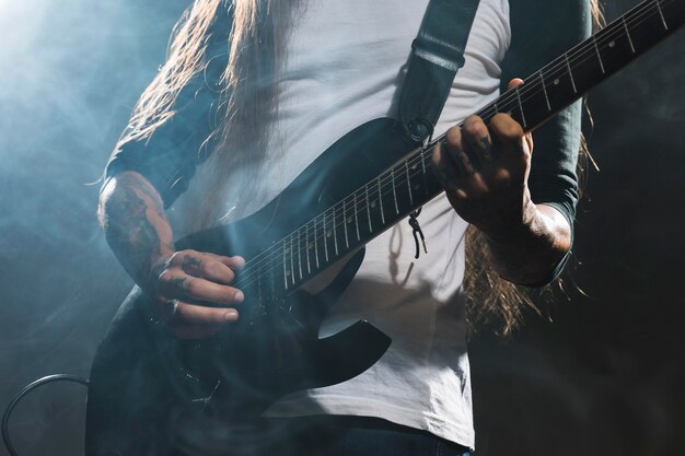 Artista che suona il colpo medio della chitarra