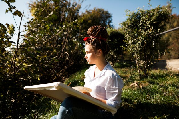 Artista femminile che dipinge all&#39;aperto