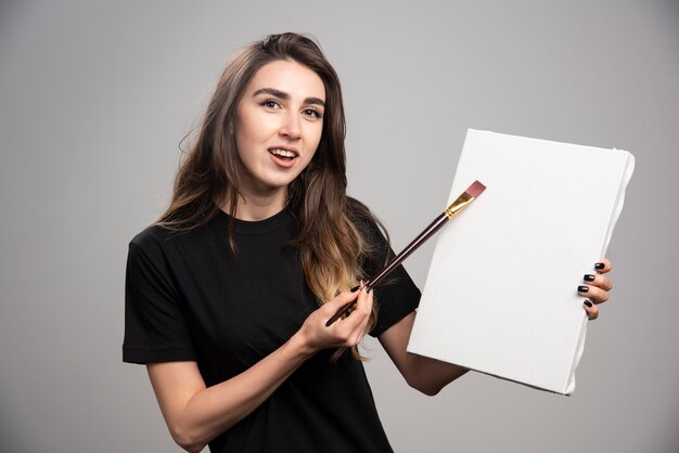 Artista femminile in pittura camicia nera su tela.