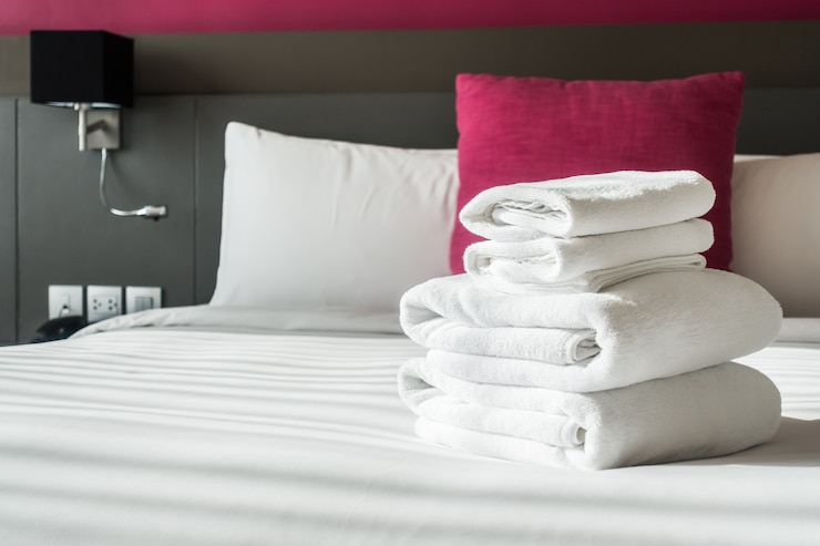 Foto gratuito asciugamani piegati sul letto.
