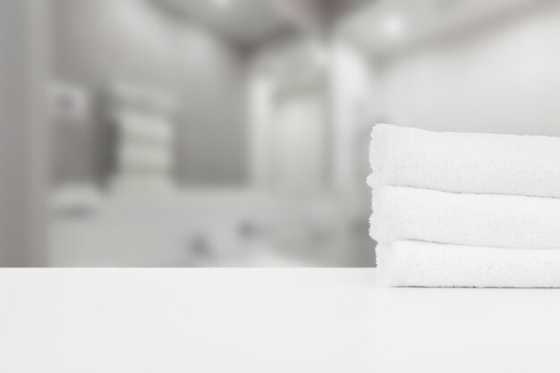 Asciugamani spa impilati bianchi sul tavolo su sfondo sfocato