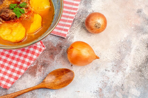 Asciugamano da cucina zuppa bozbash vista frontale un cucchiaio di legno cipolle su sfondo nudo cucina azera