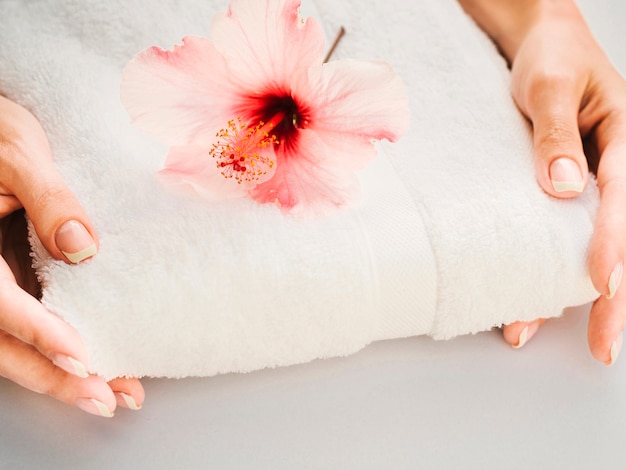 Asciugamano tenuto in mano con un fiore in cima