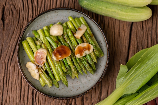 Asparagi fritti con salsa di ostriche in un piatto con peperoni