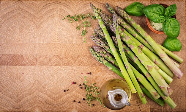 Asparagi verdi freschi su una tavola di legno rustica con lo spazio della copia. Vista dall'alto