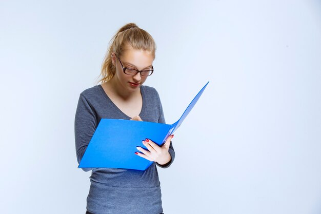 Assistente che apre la cartella del report blu e la controlla.