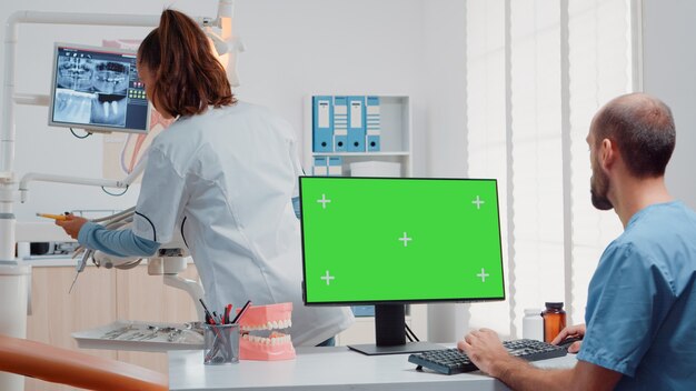 Assistente che utilizza lo schermo verde orizzontale sul computer