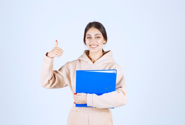 Assistente con una cartella blu che mostra il segno di godimento