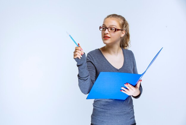 Assistente con una cartella blu che nota il suo collega e lo presenta.