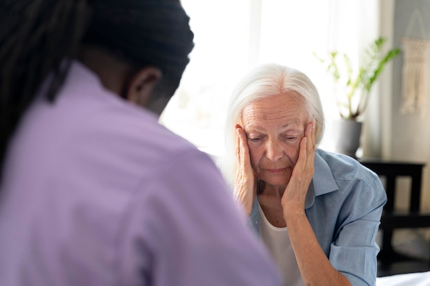 Assistente sociale africano che si prende cura di una donna anziana