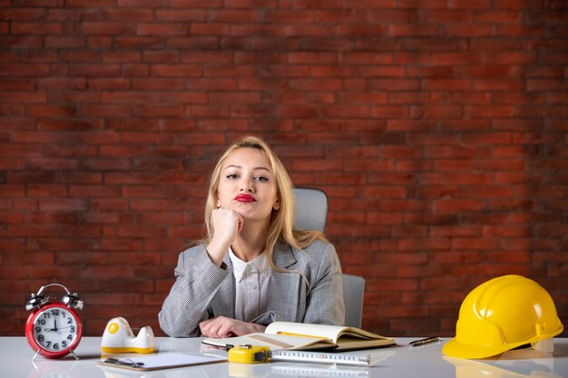 Assistente tecnico femminile di vista frontale che si siede dietro il suo posto di lavoro