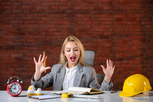 Assistente tecnico femminile di vista frontale che si siede dietro il suo posto di lavoro