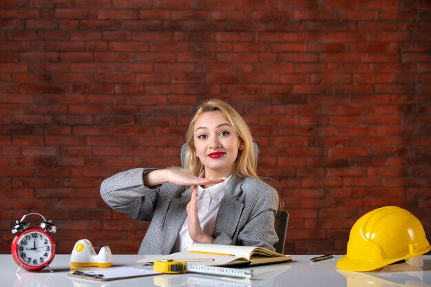 Assistente tecnico femminile di vista frontale che si siede dietro il suo posto di lavoro