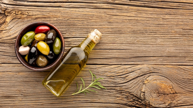 Assortimento di olive colorate con bottiglia di olio e copia spazio