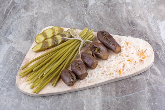 Assortimento di sottaceti fatti in casa su tavola di legno.