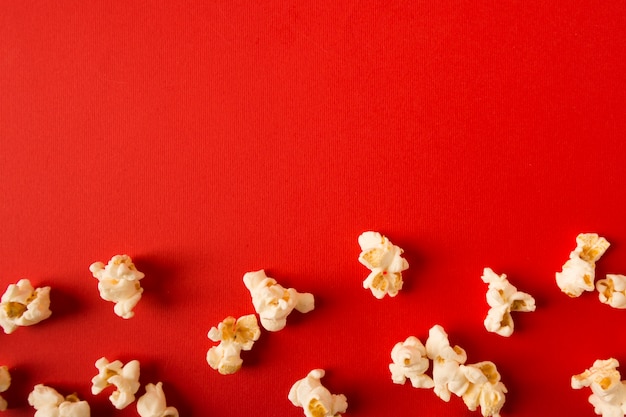 Assortimento piano del popcorn di disposizione su fondo rosso con lo spazio della copia