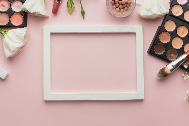 Assortimento piatto con prodotti per il trucco e cornice