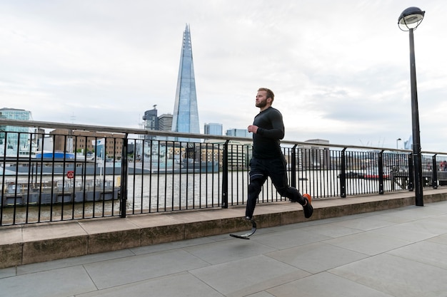 Atleta a tutto campo che corre con la protesi