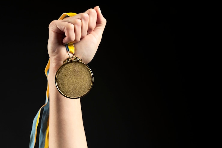 Foto gratuito atleta che tiene il primo piano della medaglia d'oro