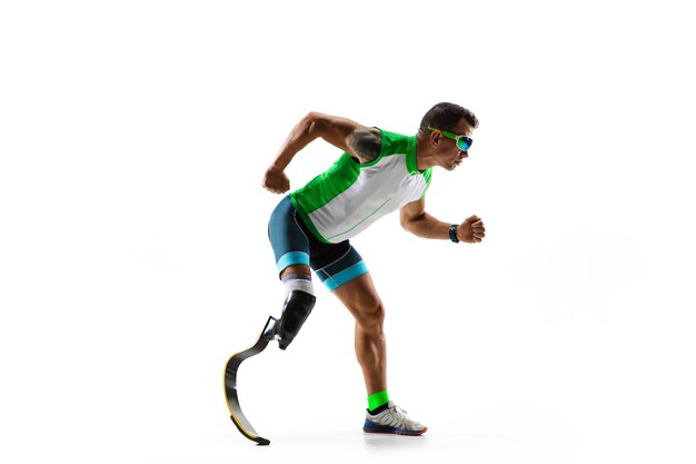 Atleta con disabilità o amputato isolato su sfondo bianco studio. Corridore maschio professionista con formazione di protesi della gamba e pratica in studio. Sport per disabili e concetto di stile di vita sano.