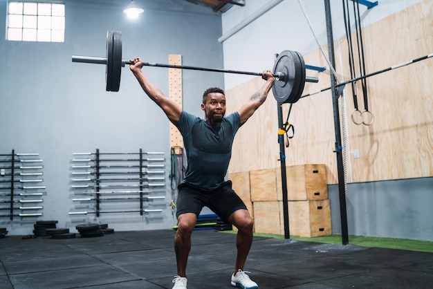 Atleta di Crossfit che fa esercizio con un bilanciere.