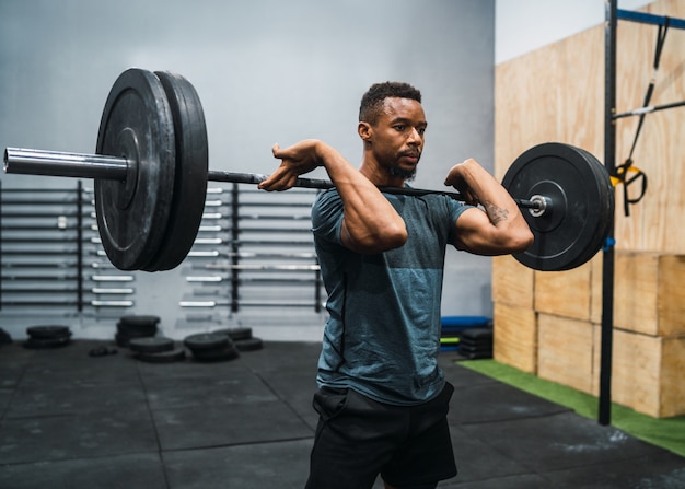 Atleta di Crossfit che fa esercizio con un bilanciere.