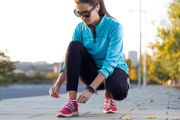 Atleta femminile che lega i pigiami per jogging.