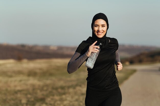 Atleta femminile dedicata che si diverte nella corsa mattutina in natura Spazio di copia