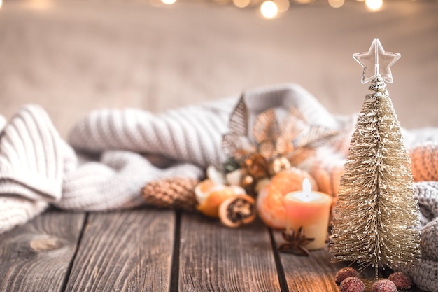 Atmosfera accogliente di Natale festivo con decorazioni per la casa e mandarini su uno sfondo di legno, concetto di comfort domestico