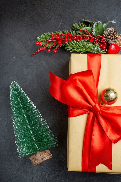 Atmosfera natalizia con bellissimi regali con nastro a forma di fiocco e accessori per la decorazione di rami di abete Calza di Natale su uno sfondo scuro