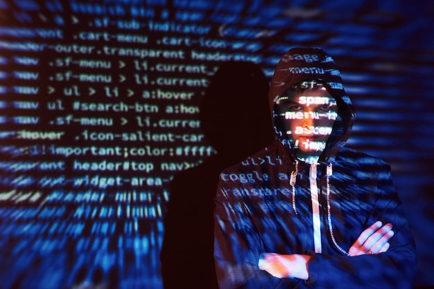 Attacco informatico con hacker incappucciato irriconoscibile utilizzando la realtà virtuale, effetto glitch digitale