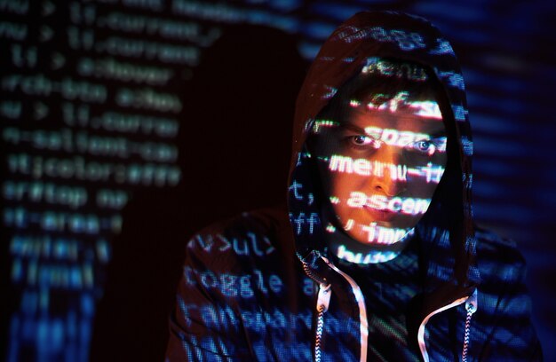 Attacco informatico con hacker incappucciato irriconoscibile utilizzando la realtà virtuale, effetto glitch digitale